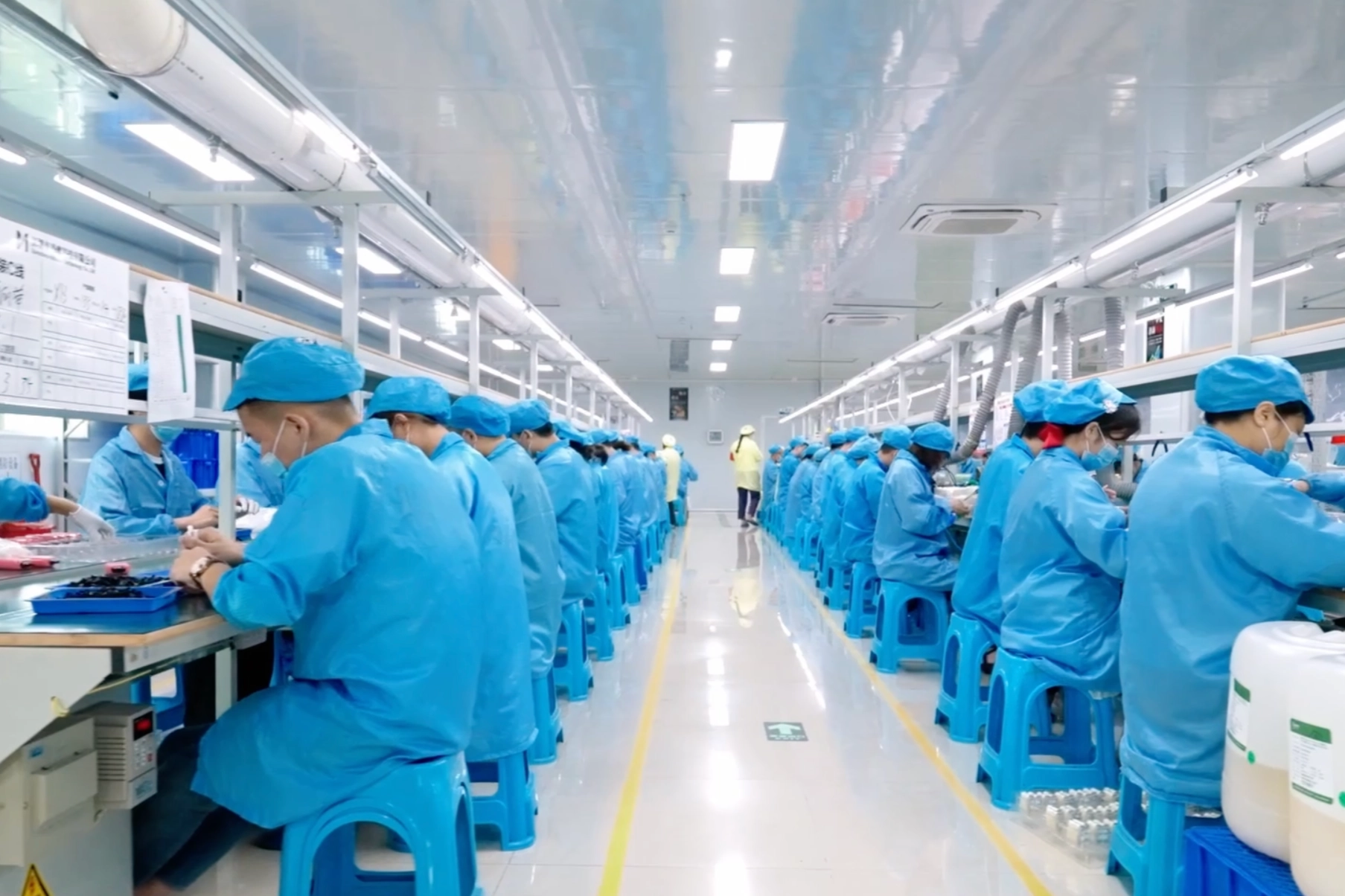 Cleanroom e-cigarette assembly line with workers in blue uniforms – Vaporeur vape factory